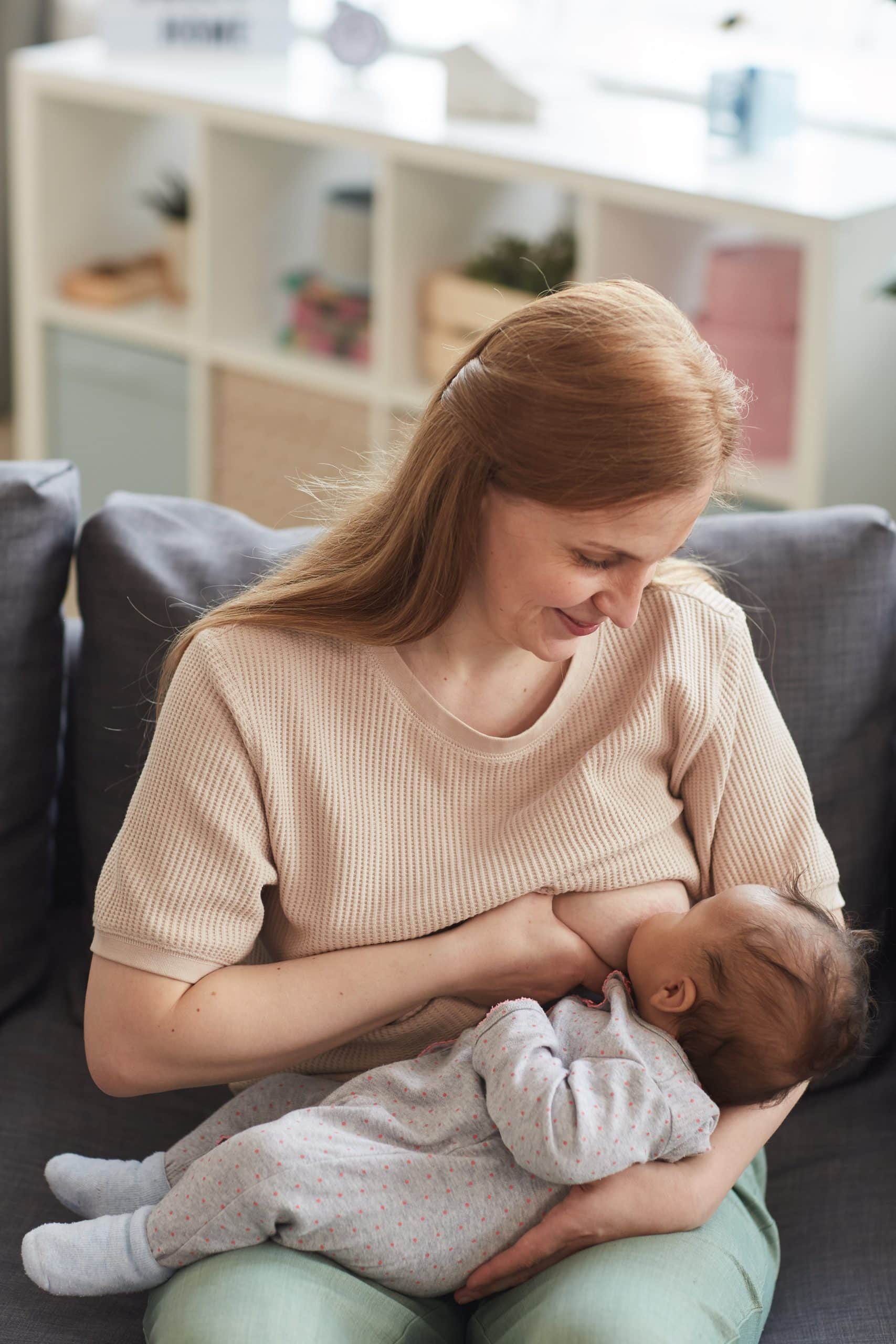 older mom nursing wearing a sweater